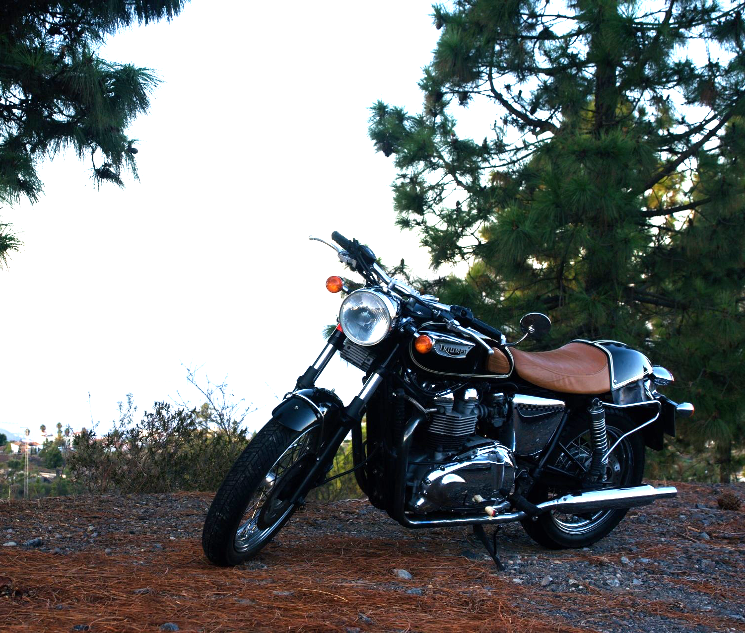 A black motorcycle is parked on a gravel road