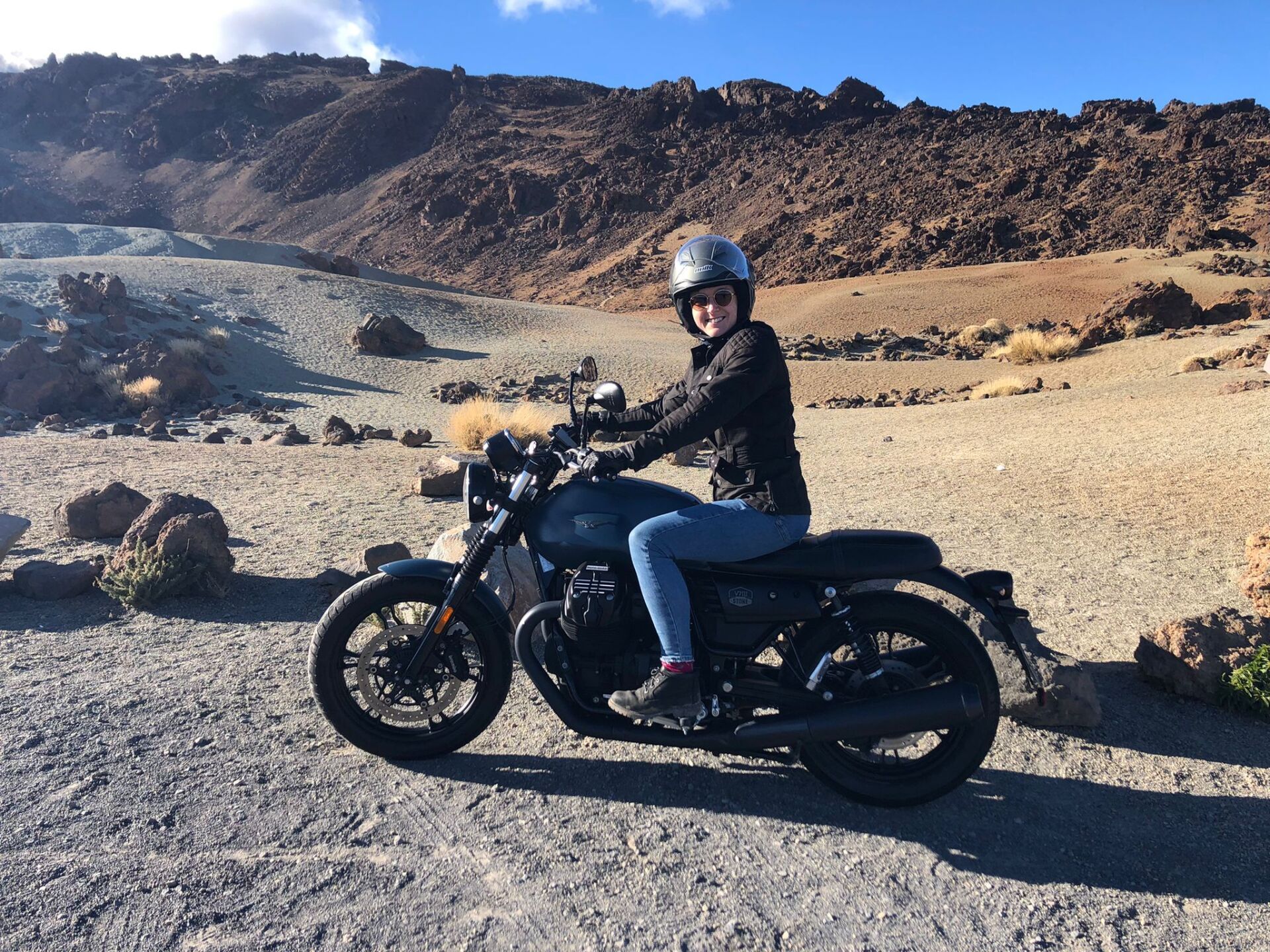 A person is sitting on a motorcycle in the desert