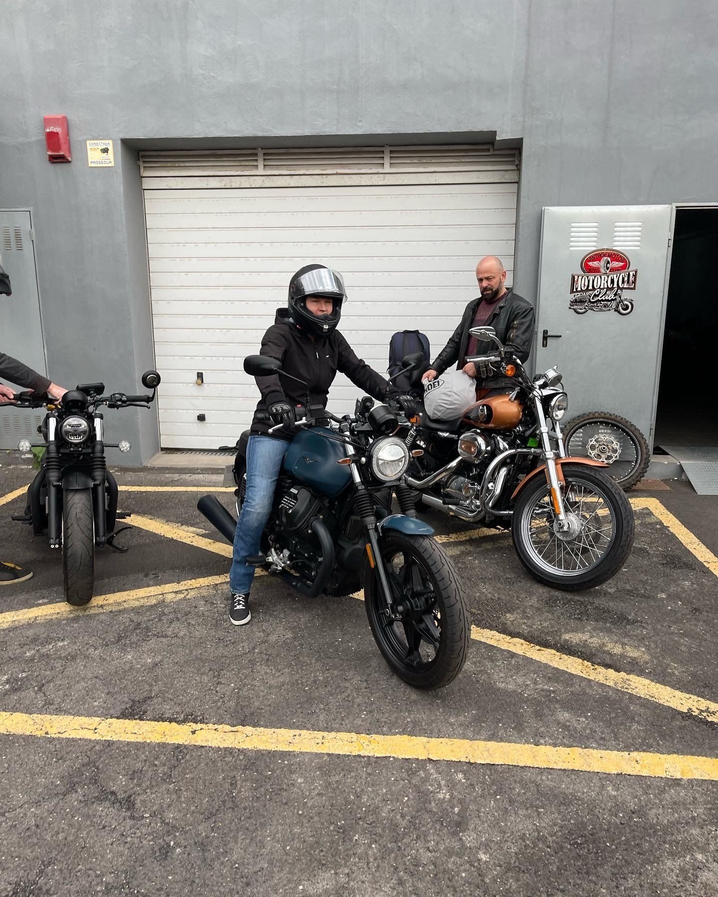 A group of people are riding motorcycles in a parking lot.