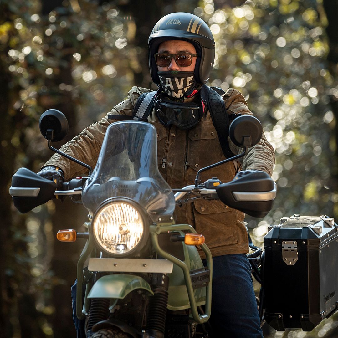 A man is riding a motorcycle in the woods.