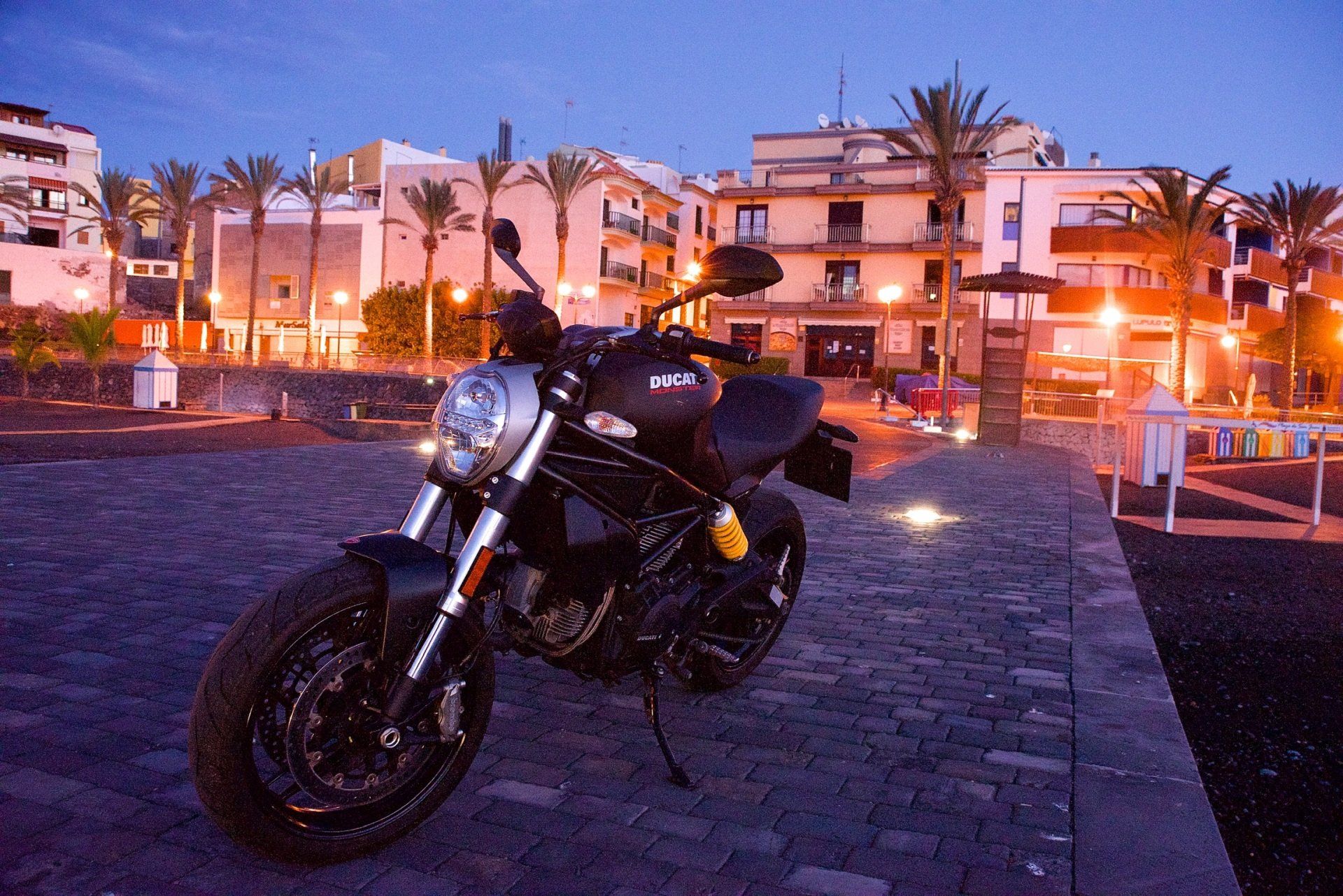 A motorcycle is parked in front of a building at night