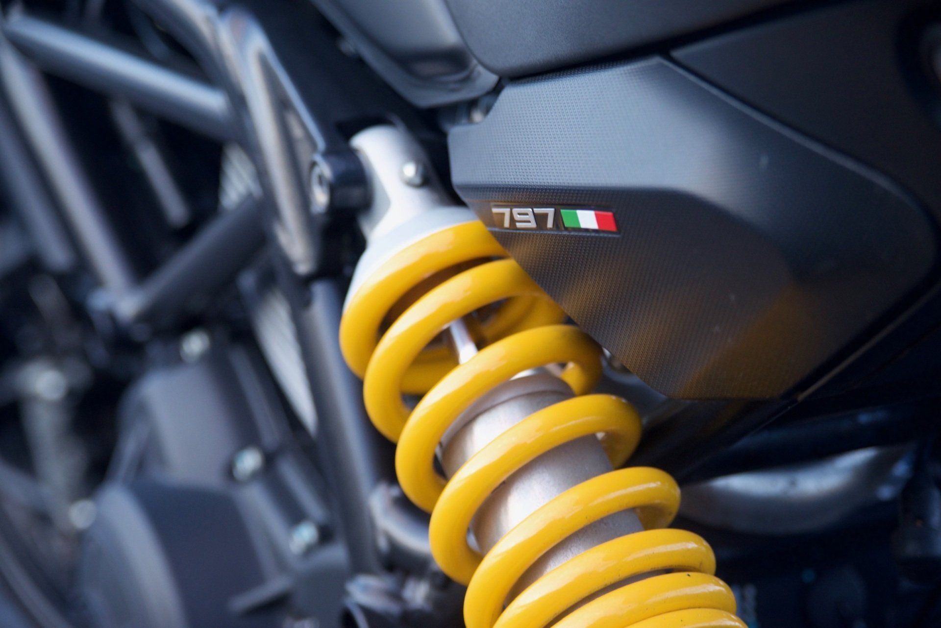 A close up of a yellow shock absorber on a motorcycle