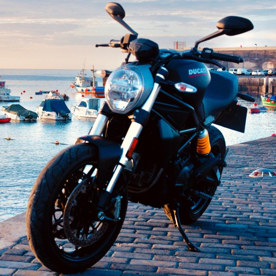 A ducati motorcycle is parked on a cobblestone street