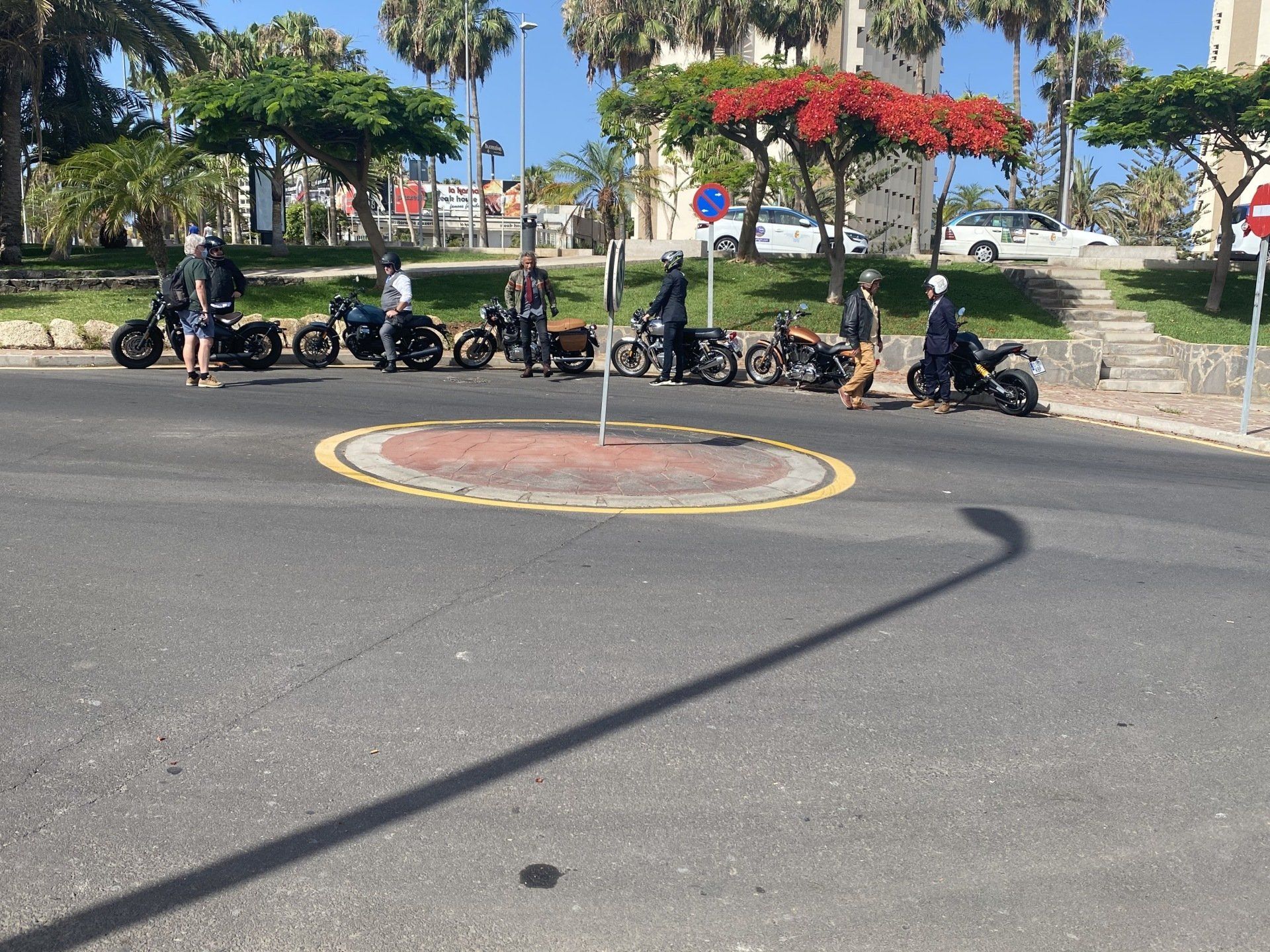 A group of motorcycles are parked on the side of the road