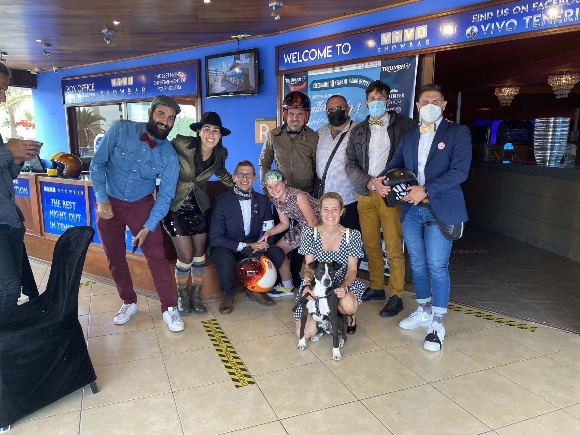 A group of people posing for a picture with a dog.
