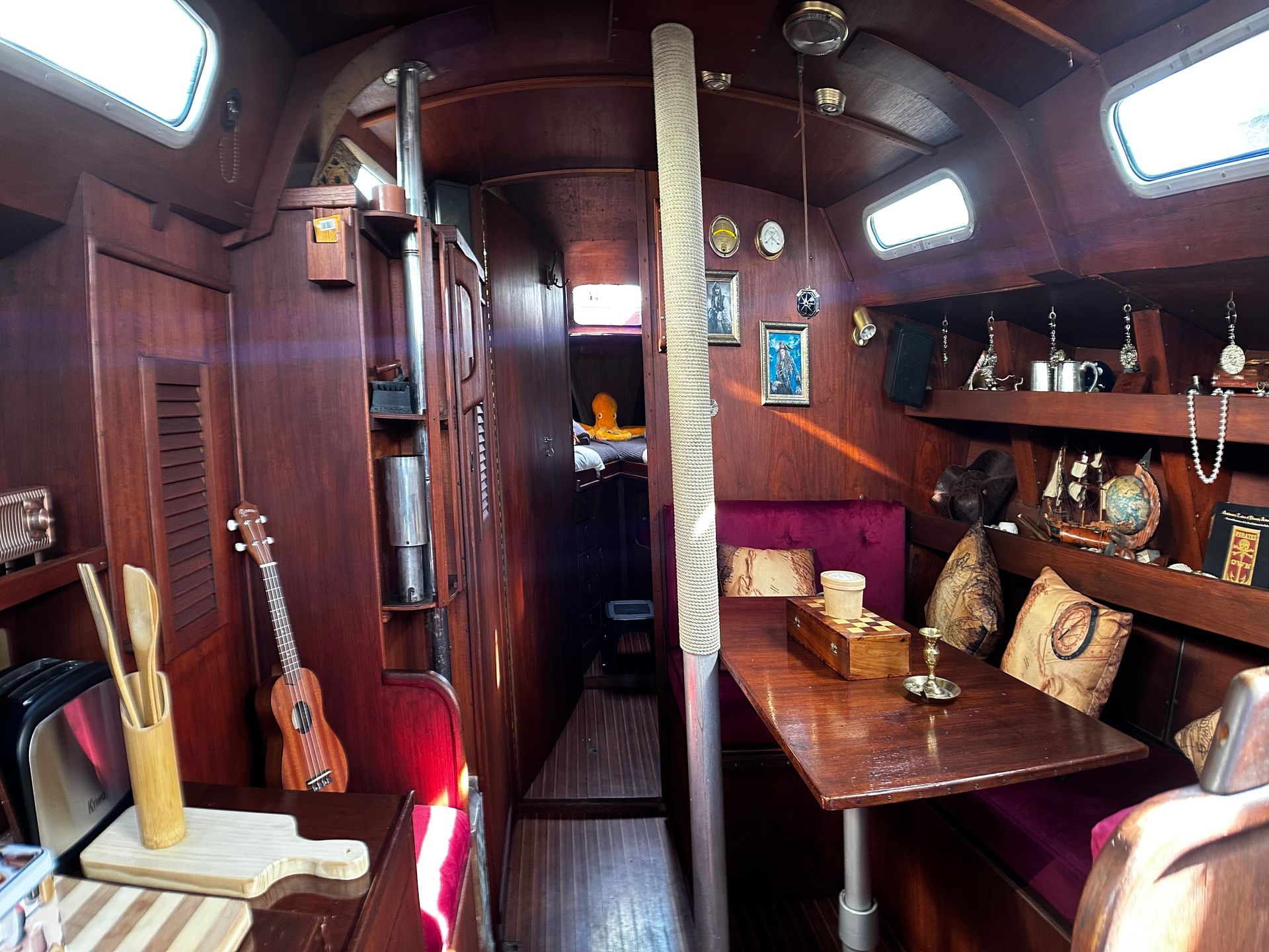 The inside of a boat with a table and chairs.