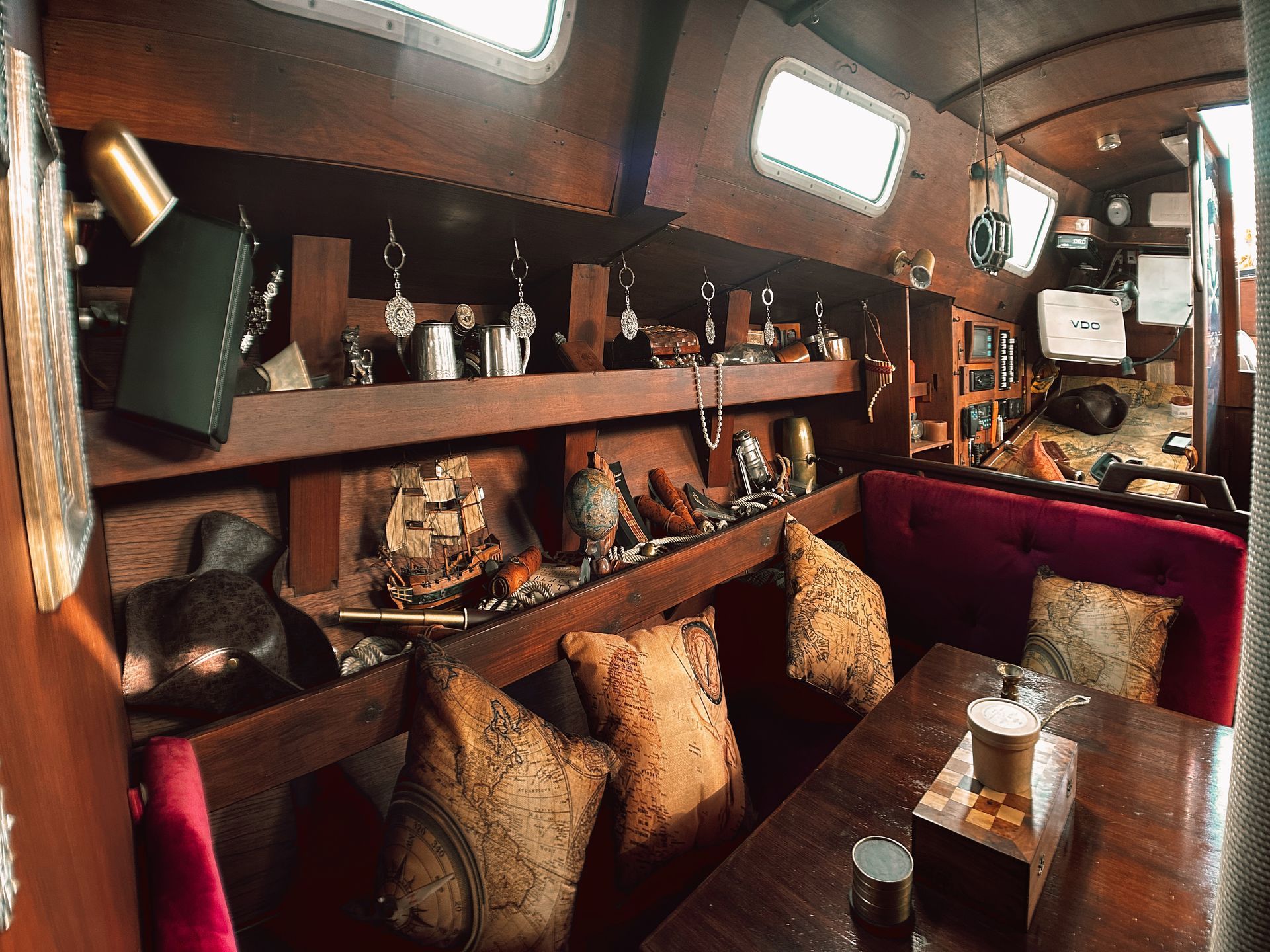 The inside of a boat with a table and pillows