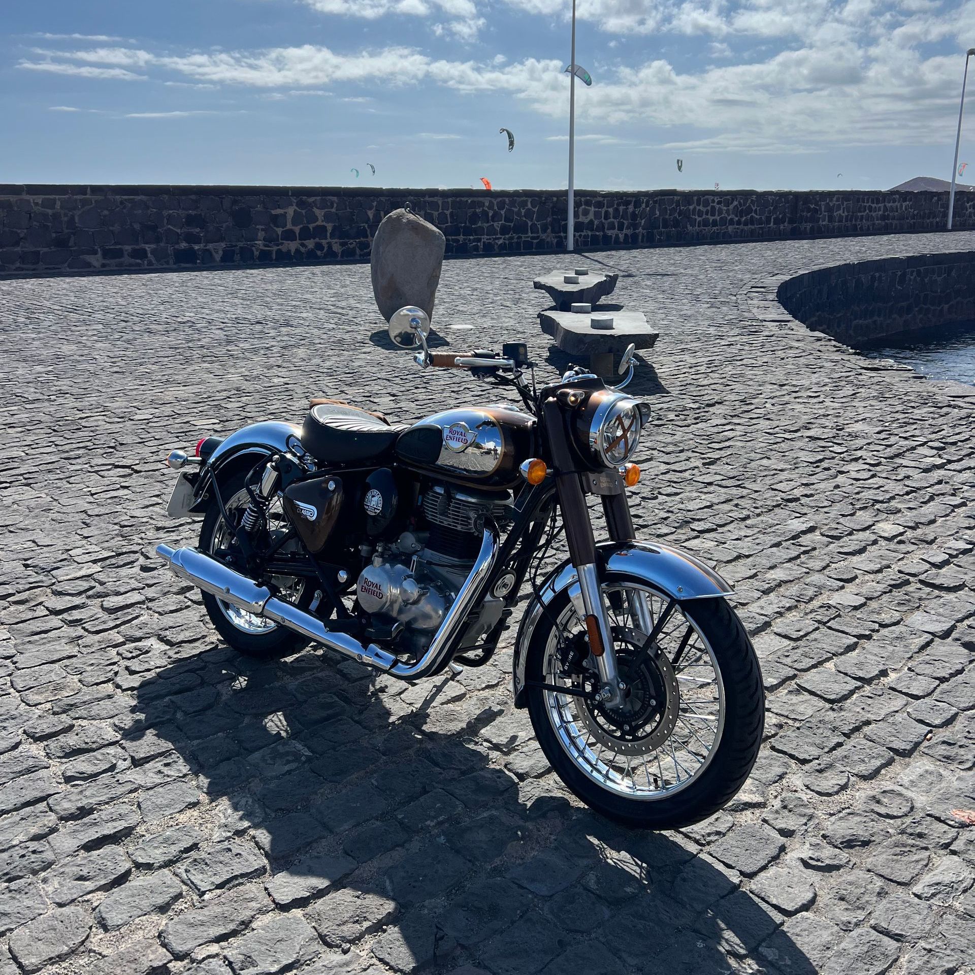 A motorcycle is parked on a cobblestone road