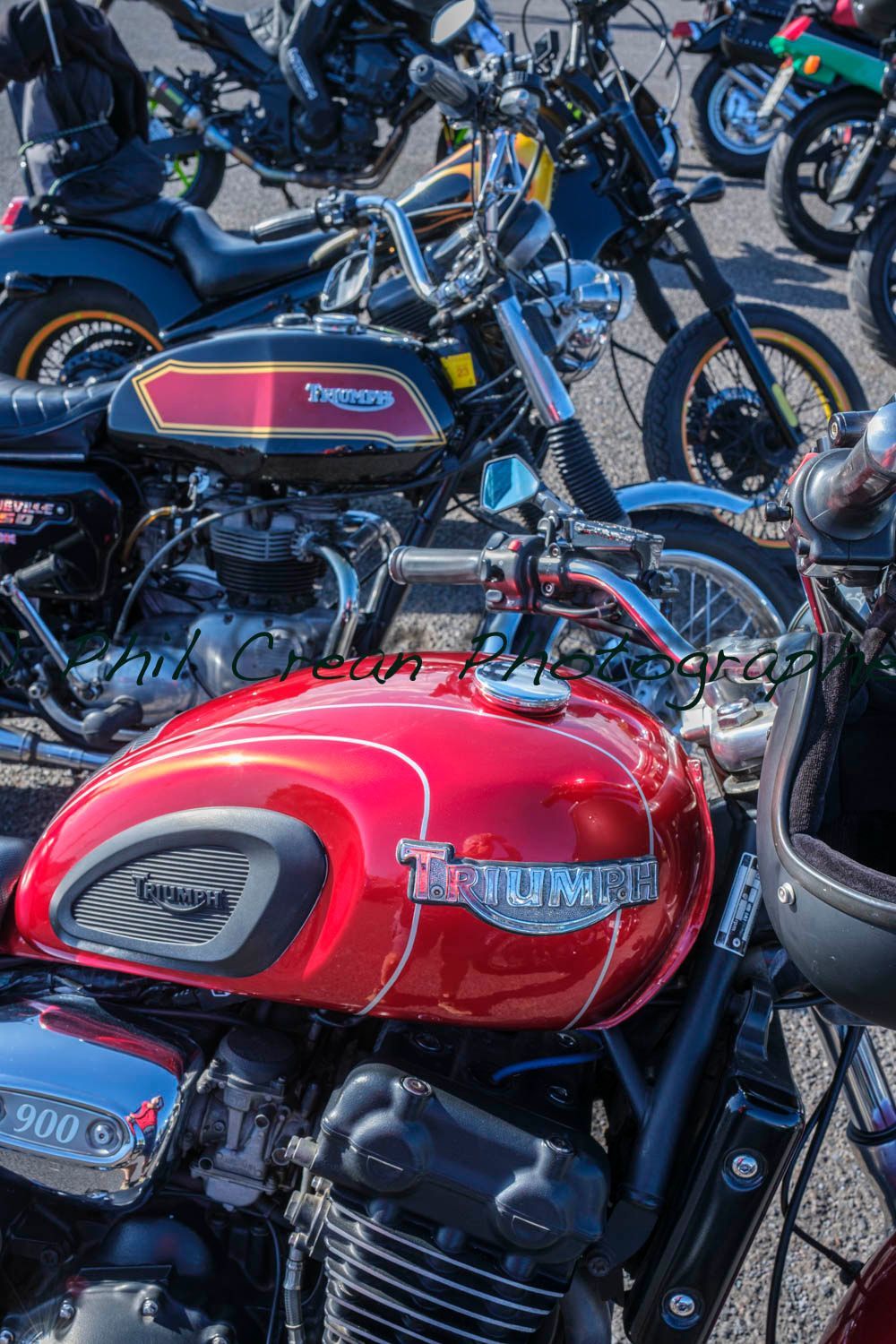 A row of motorcycles are parked next to each other in a parking lot.