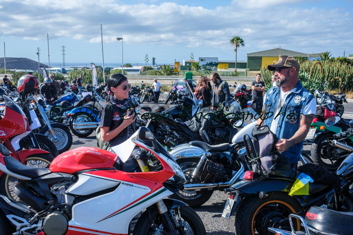 A man and a boy are sitting on motorcycles in a parking lot.