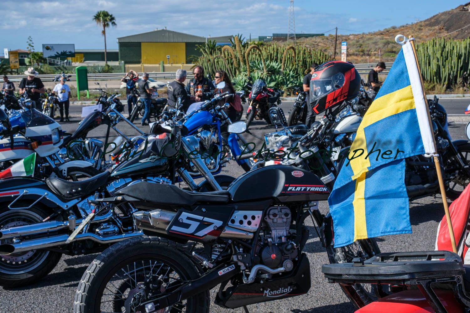 A group of motorcycles are parked on the side of the road