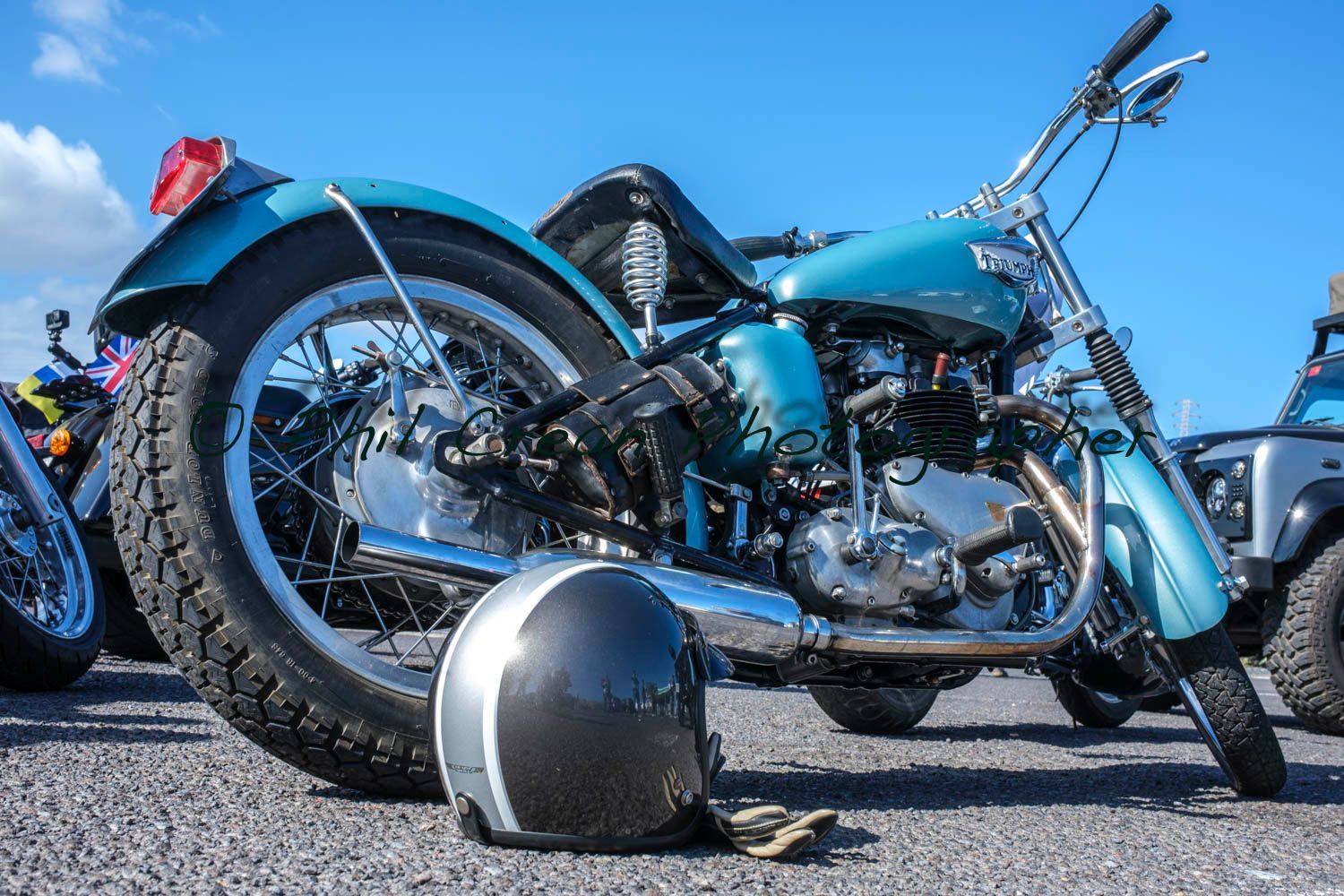 A motorcycle is parked next to a helmet on the ground.