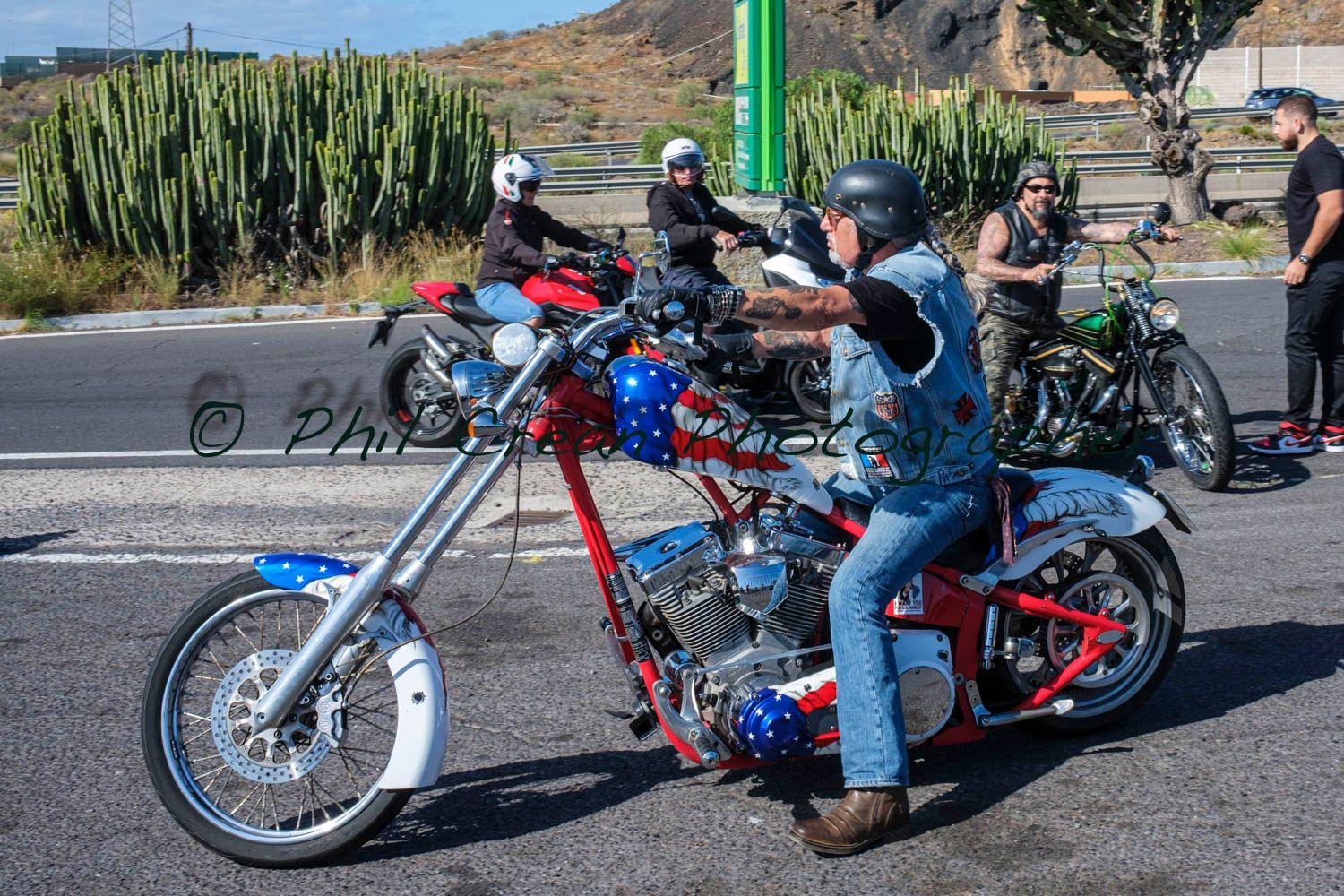 A man is sitting on a red and blue motorcycle