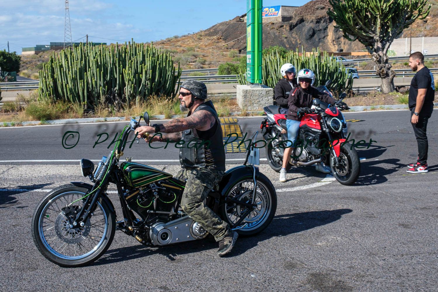 A man is riding a motorcycle down a road.