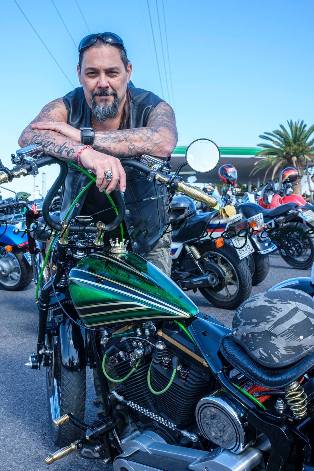 A man is leaning on the handlebars of a motorcycle.