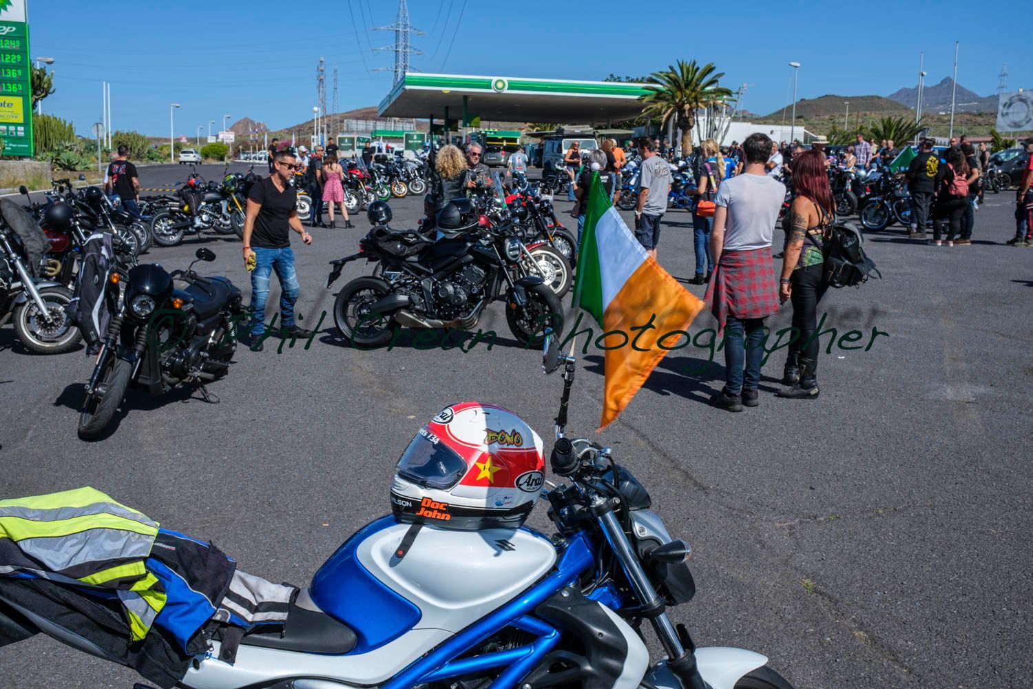 A blue and white motorcycle is parked in front of a gas station