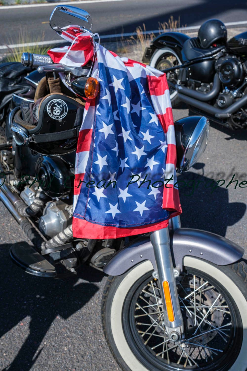 An american flag is hanging from the front of a motorcycle.