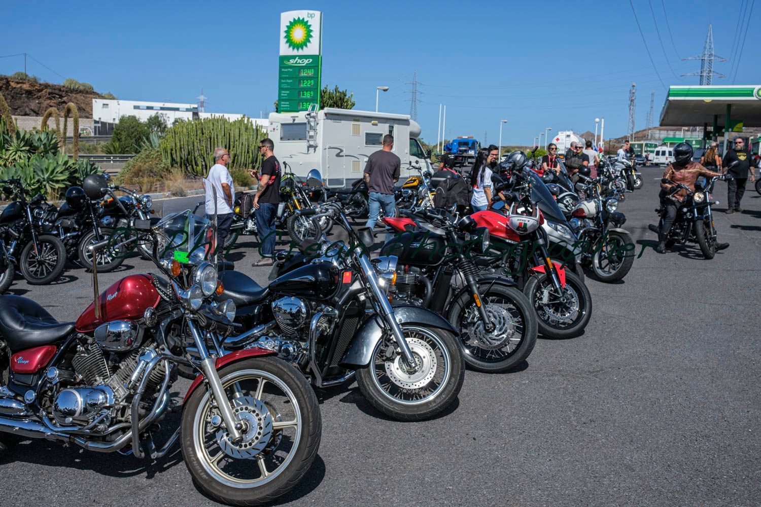 A group of motorcycles are parked in front of a bp gas station.