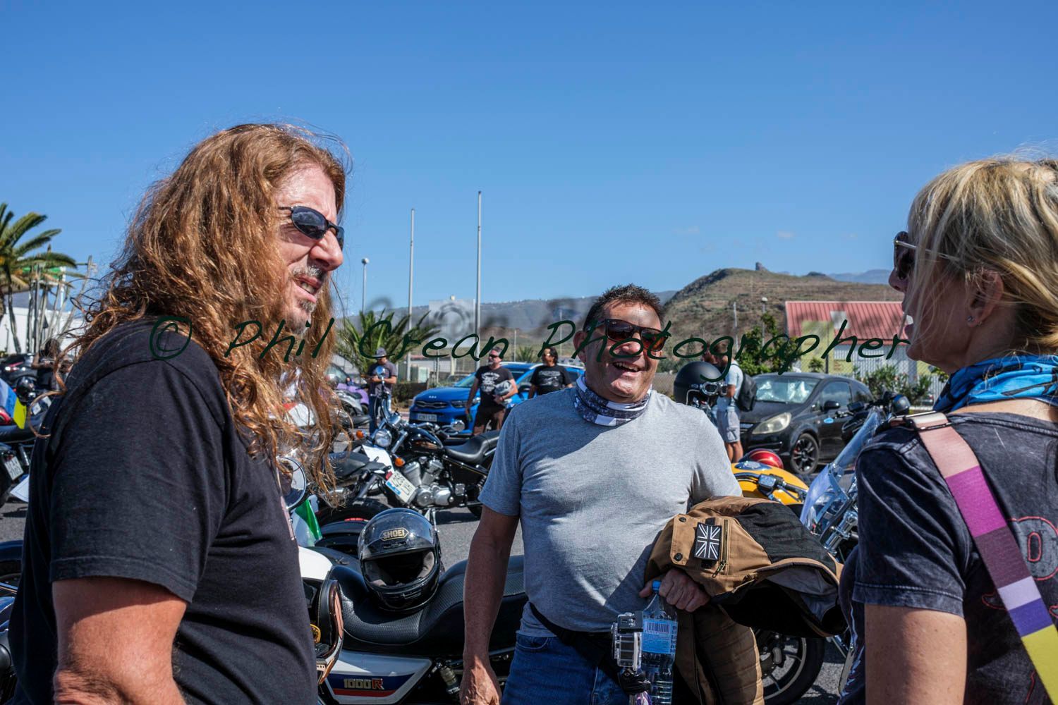 A group of people are standing next to each other in front of motorcycles.