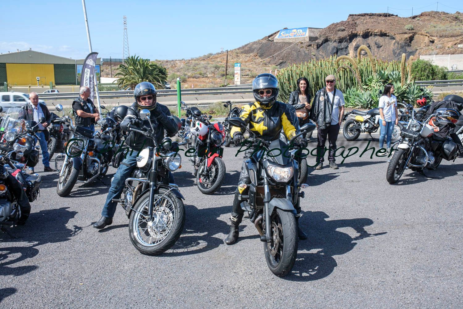 A group of people are riding motorcycles in a parking lot.