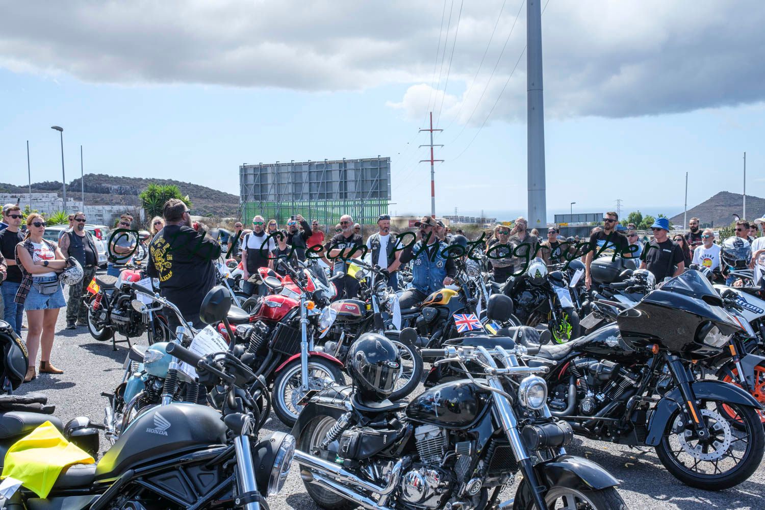A lot of motorcycles are parked in a parking lot.
