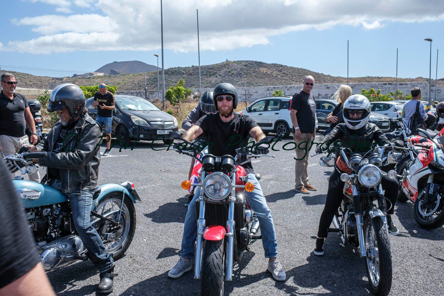A group of people are riding motorcycles in a parking lot.
