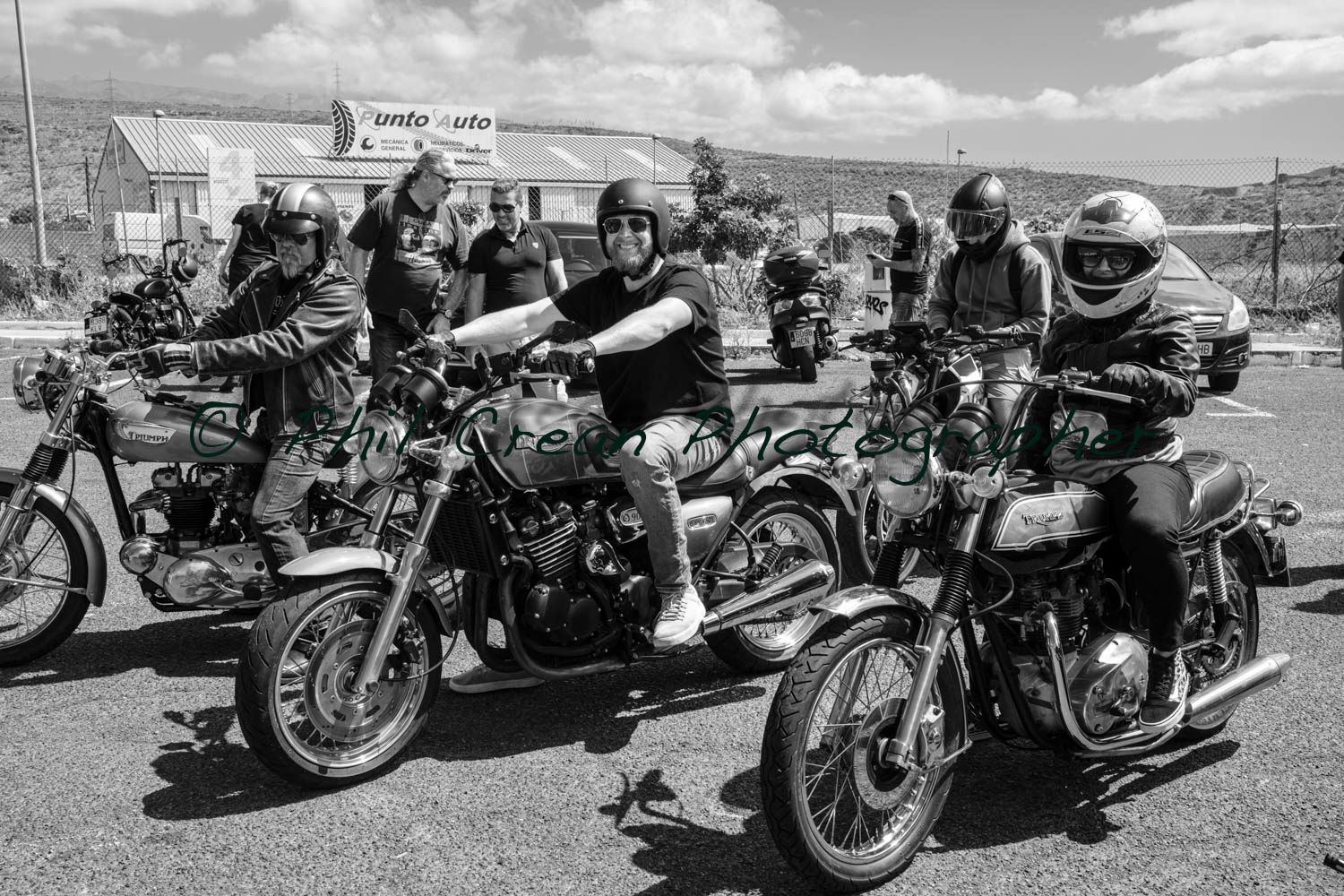 A group of people are riding motorcycles in a black and white photo.