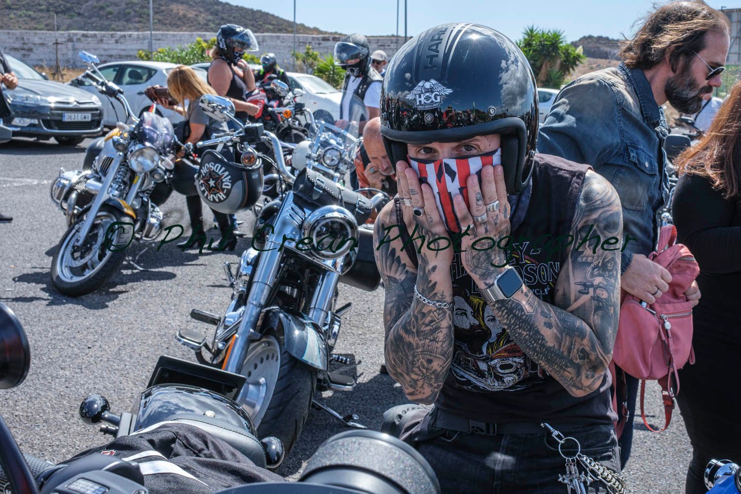 A man wearing a helmet and a bandana is sitting on a motorcycle.