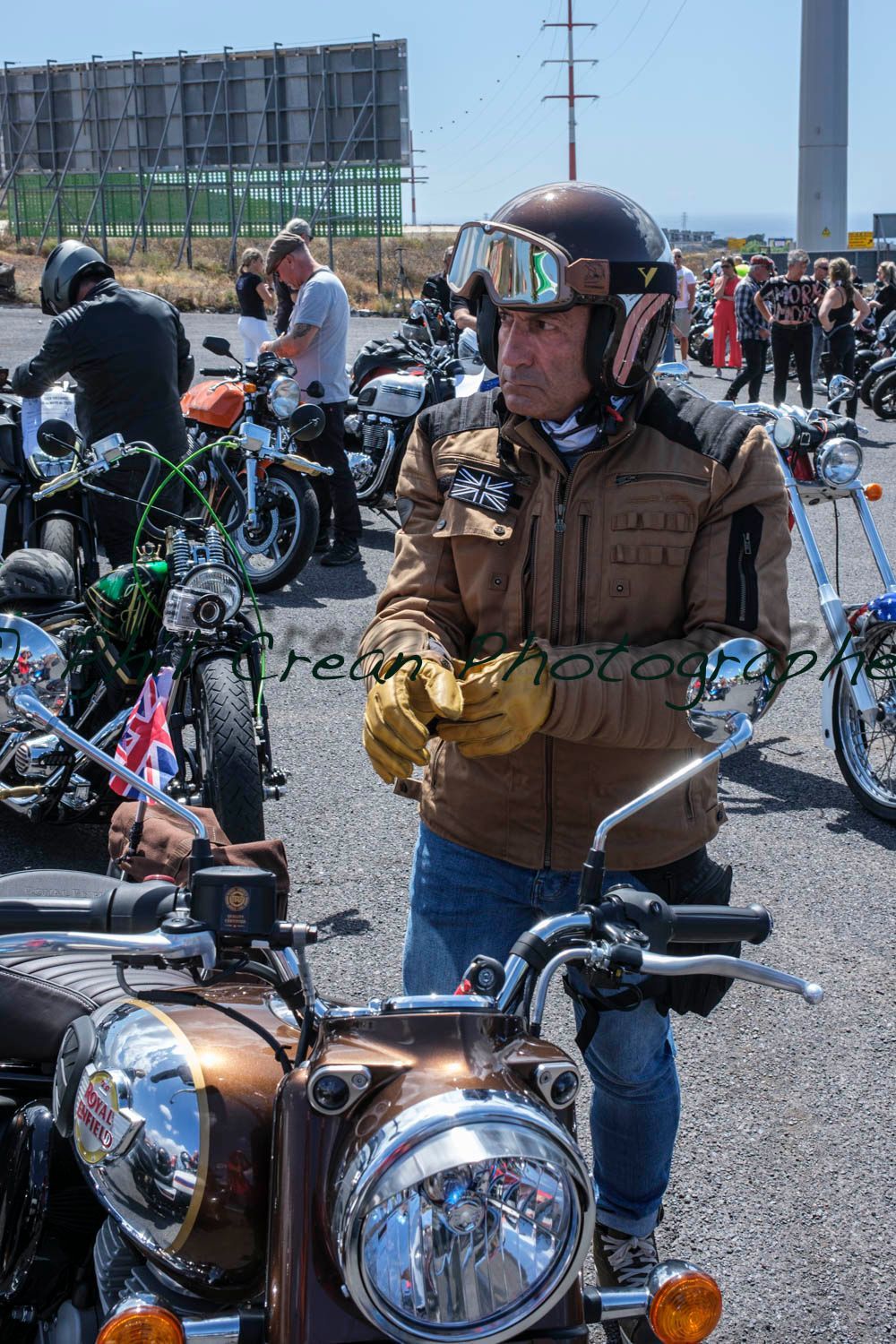 A man wearing a helmet and goggles is standing next to a motorcycle.
