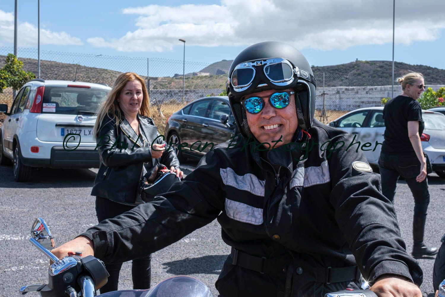 A man wearing a helmet and goggles is riding a motorcycle.