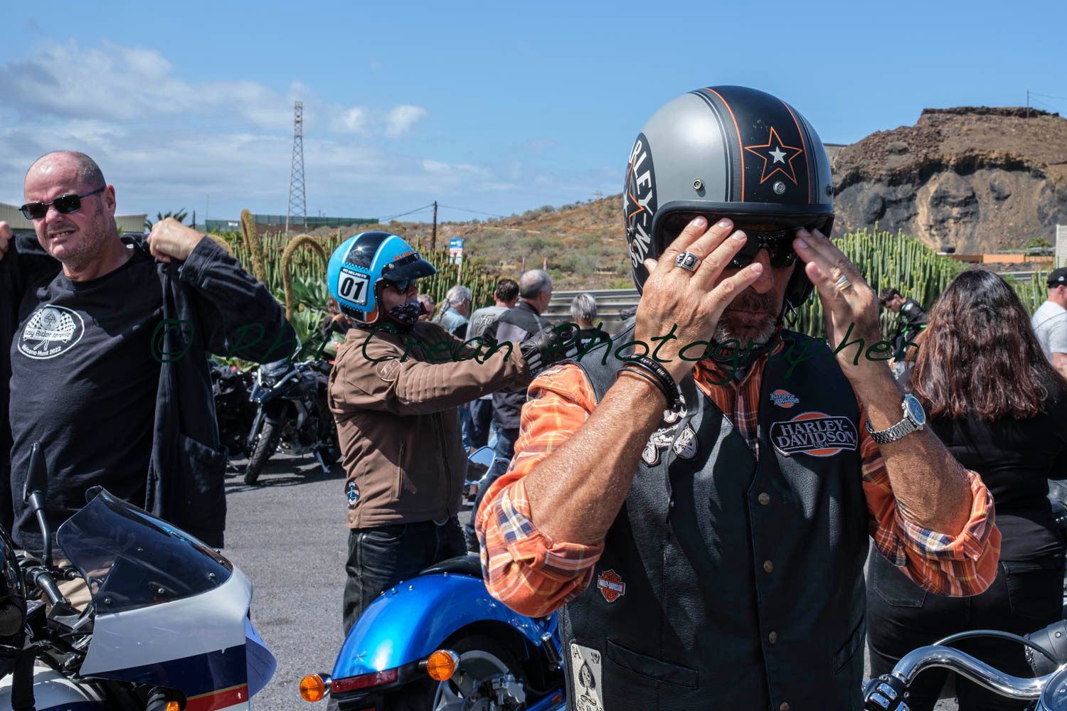 A man wearing a helmet is standing in front of a motorcycle