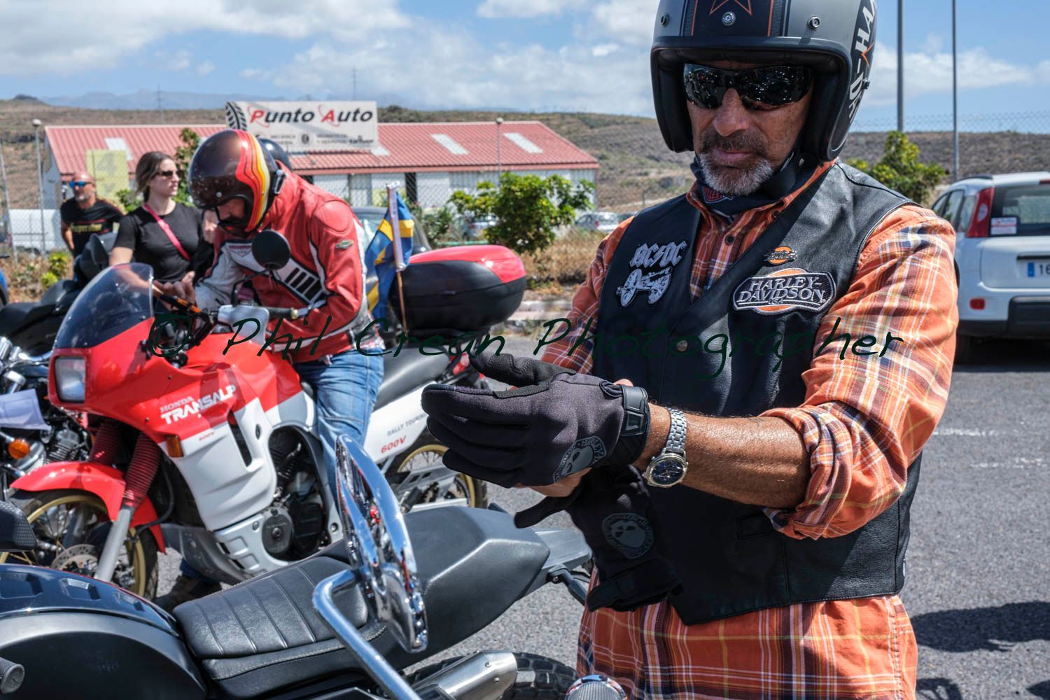 A man wearing a helmet is standing next to a motorcycle