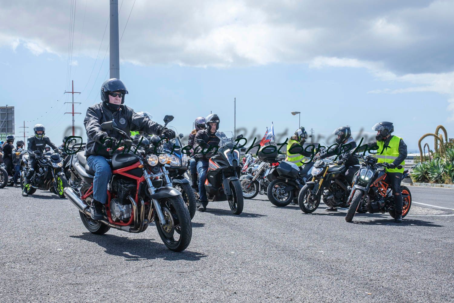 A group of people are riding motorcycles down a street.