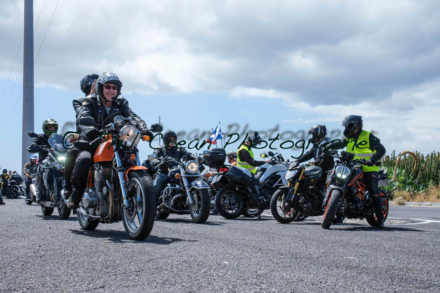 A group of people are riding motorcycles down a road.