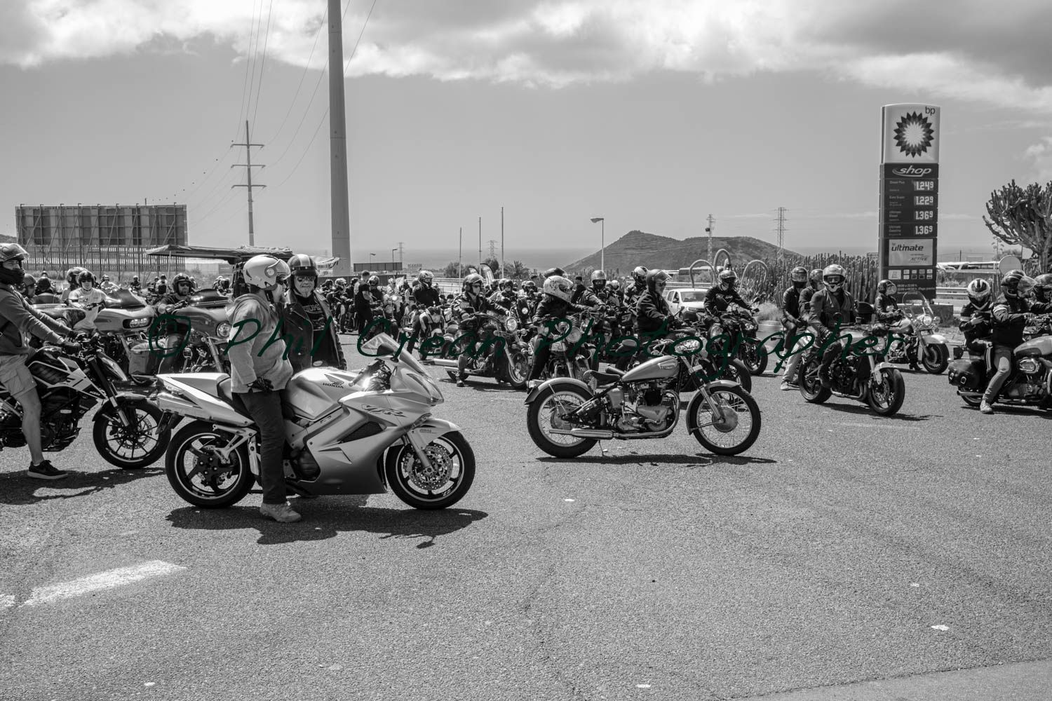 A black and white photo of a group of people riding motorcycles