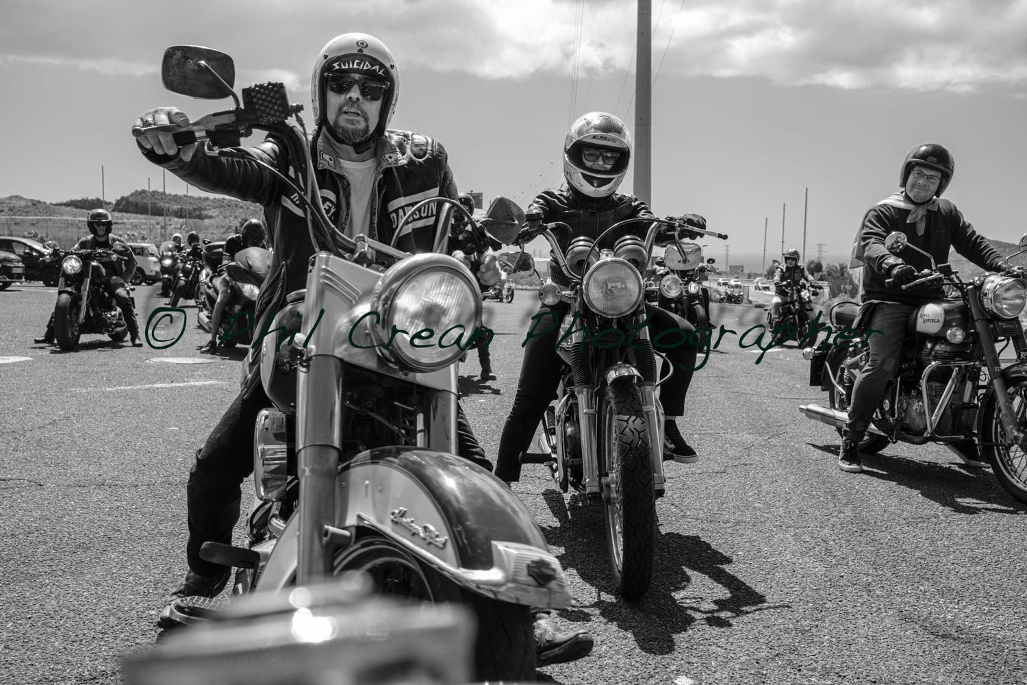 A group of people are riding motorcycles down a road.