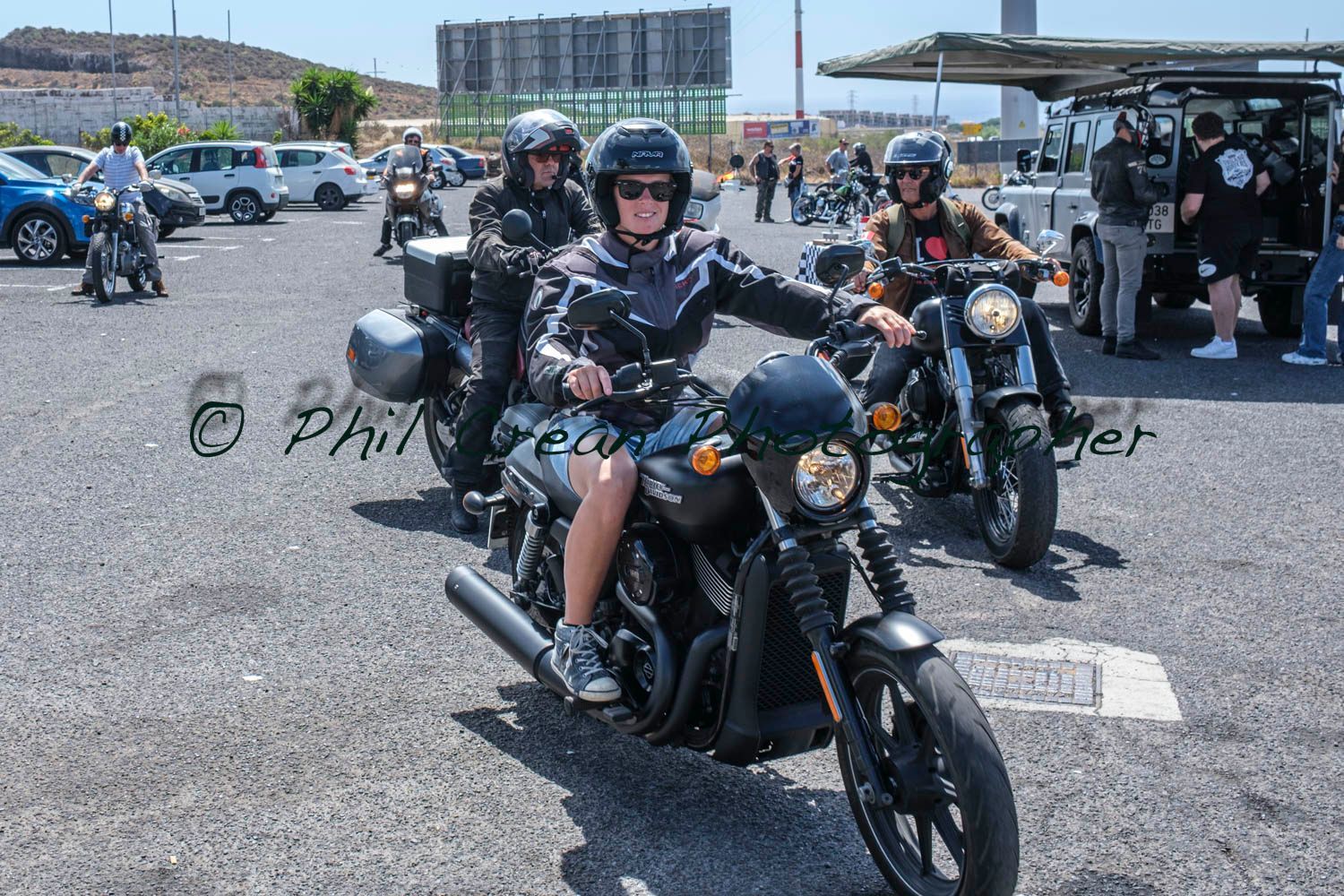A group of people are riding motorcycles in a parking lot.