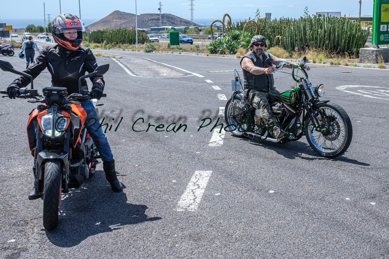A man and a woman are riding motorcycles on a road.