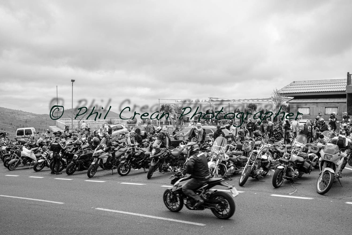 A black and white photo of a group of people riding motorcycles