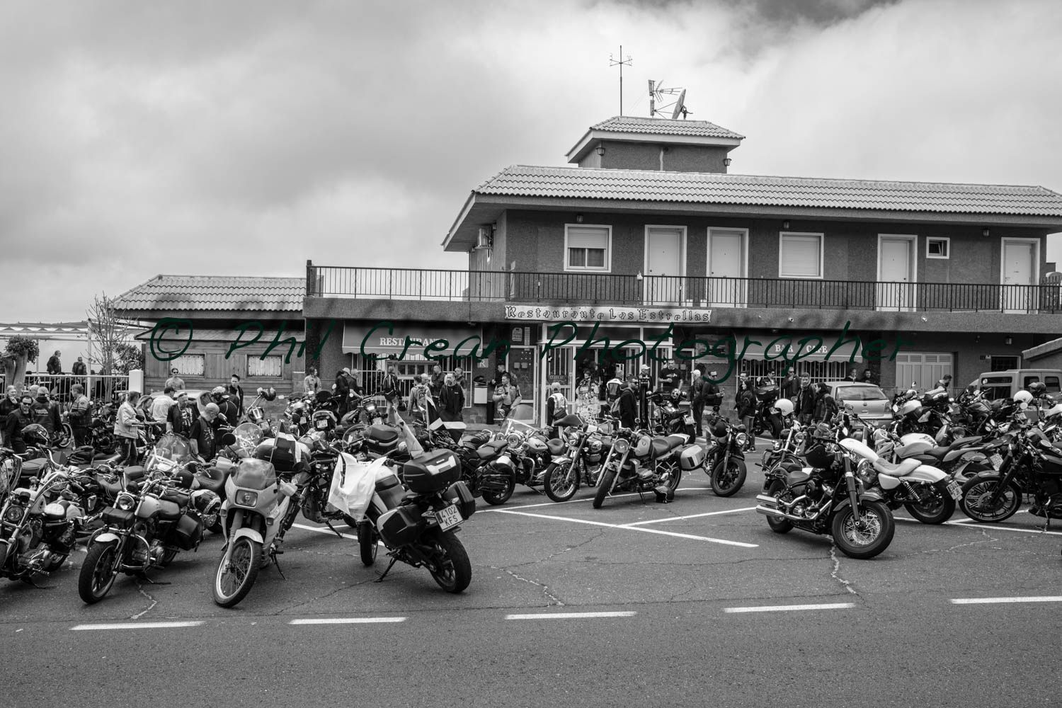 A black and white photo of motorcycles parked in front of a building