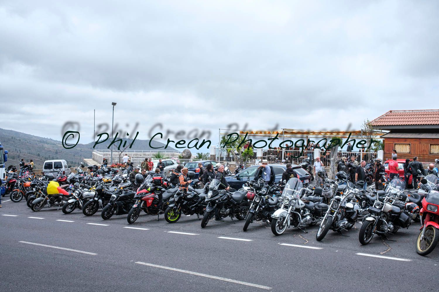 A bunch of motorcycles are parked on the side of the road