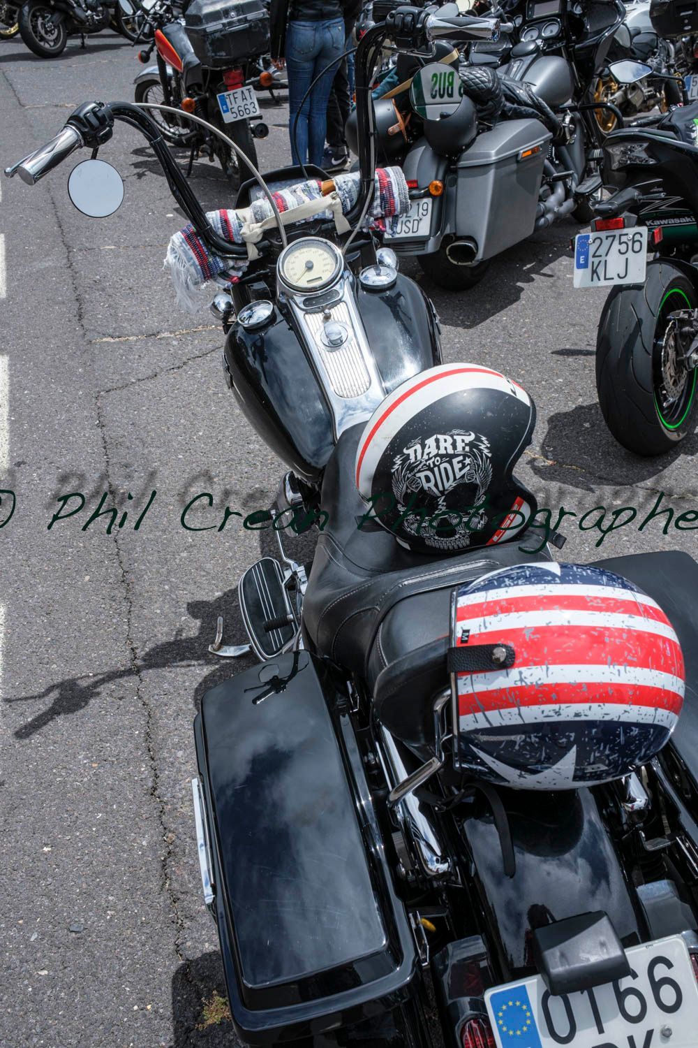A black motorcycle with an american flag helmet on the back seat