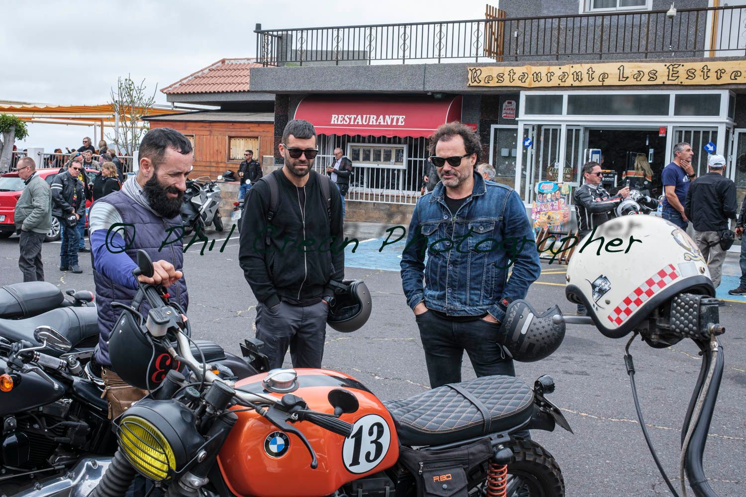 A group of men are standing around a row of motorcycles.