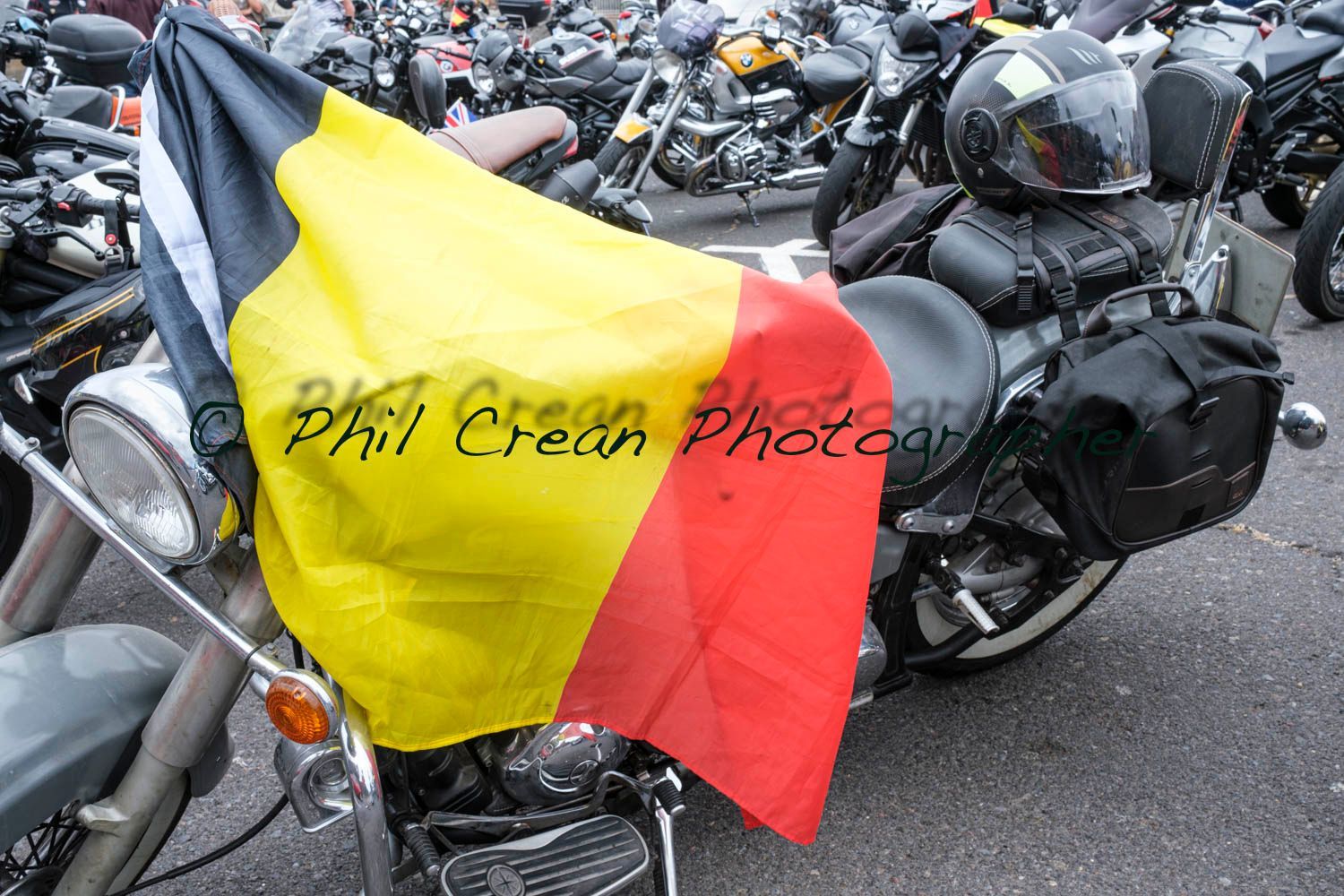 A yellow black and red flag is draped over a motorcycle