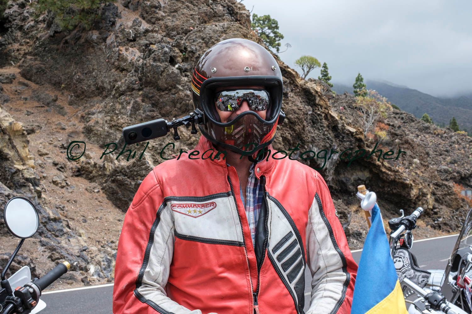 A man wearing a helmet and goggles is holding a flag