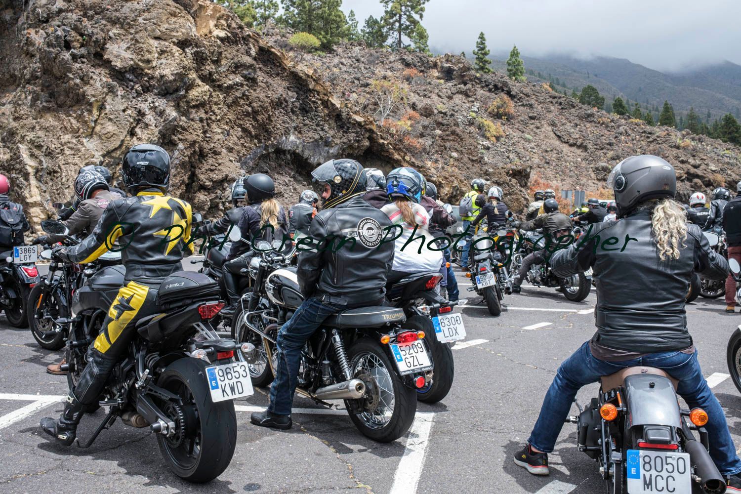 A group of people are riding motorcycles down a road.
