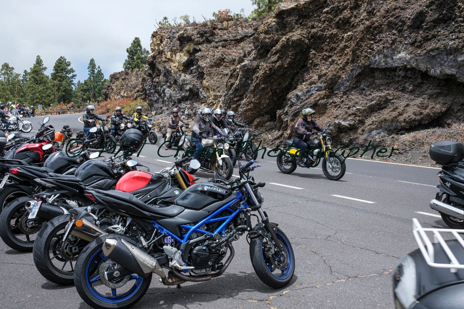 A group of motorcycles are parked on the side of the road.