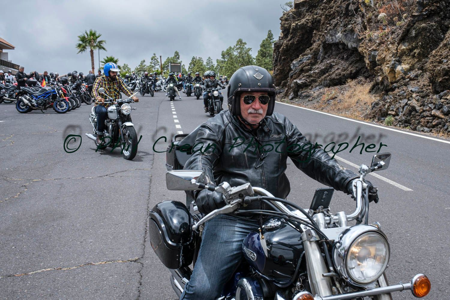 A man is riding a motorcycle down a road