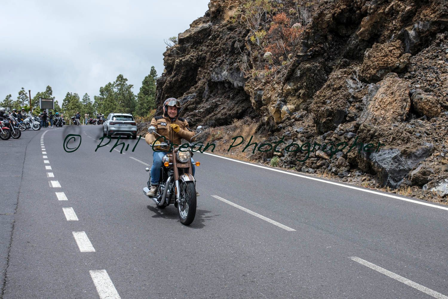 A man is riding a motorcycle down a road.