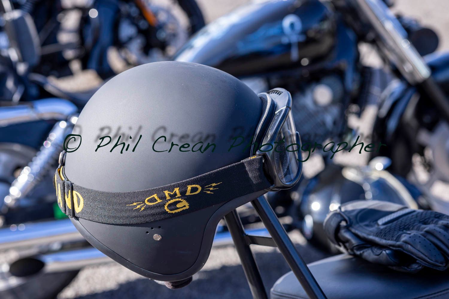 A black motorcycle helmet is sitting on the back of a motorcycle.